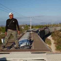 A migrant rides the roof of a train traveling North (photo by Marc Silver)